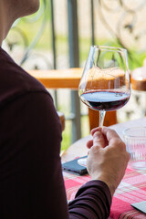 A person is holding a glass of red wine 