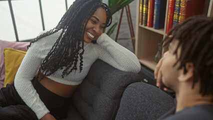 A smiling woman and a man enjoy a heartwarming moment together in a cozy, modern living room space.
