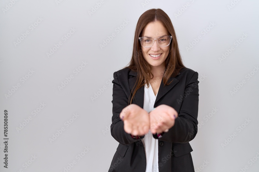 Wall mural Beautiful brunette woman wearing business jacket and glasses smiling with hands palms together receiving or giving gesture. hold and protection