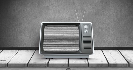 Digital image of an old television with static placed on a wooden deck 
