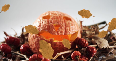 Fototapeta premium Image of orange autumn leaves falling over pumpkin