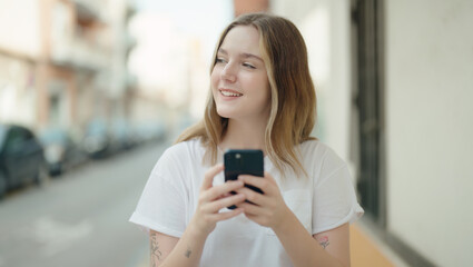 Young caucasian woman smiling confident using smartphone at street