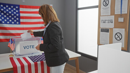 Mature woman voting in an american election booth with the us flag in the background