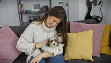 Smiling woman cuddles with biewer terrier in a cozy living room