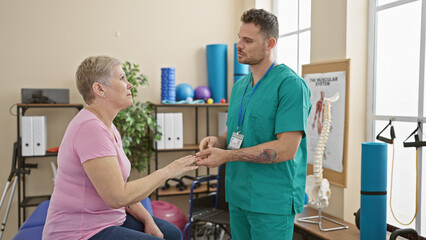 A woman patient engages with a male physiotherapist in a well-lit physiotherapy clinic room.