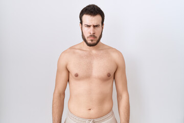 Fototapeta premium Young hispanic man standing shirtless over white background skeptic and nervous, frowning upset because of problem. negative person.