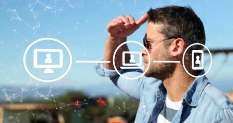 Image of connections with icons over caucasian man using smartphone