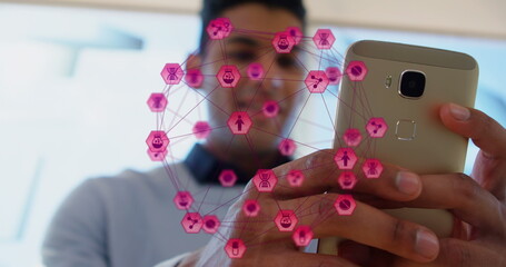 Image of globe of digital icons over biracial man using smartphone at office