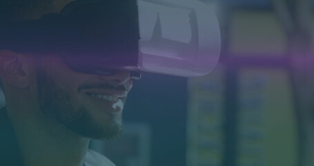 Image of blue and pink light trails moving over biracial man wearing vr headset - Powered by Adobe