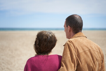 Mature couple in the beach looking at the sea