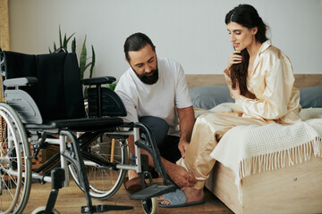 handsome loving man in homewear helping his disabled wife to change into pajama in bedroom at home - obrazy, fototapety, plakaty