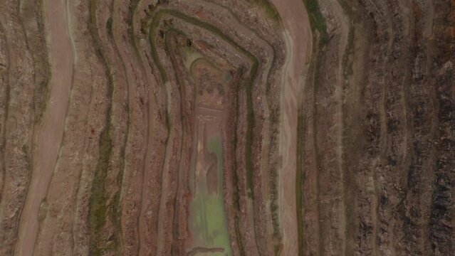 Aerial fly over over croft quarry digging abandoned site with gravel road and no machinery. Layers and natural earth resources 