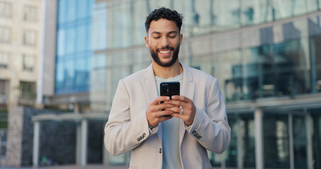 Happy, city and man with smartphone, business and typing email with positive news and online...