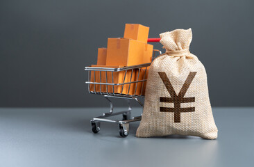 Shopping cart with boxes of goods and japanese yen money bag. Profit from the sale of goods....