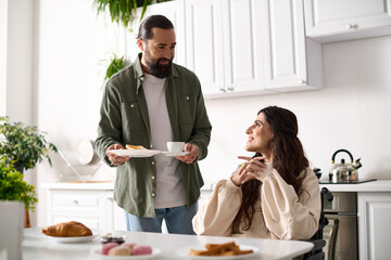 bearded loving man bringing his cheerful wife with disability toasts and hot coffee at breakfast
