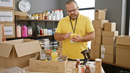 Bearded, middle-aged, handsome caucasian man is a dedicated volunteer at the charity center,...