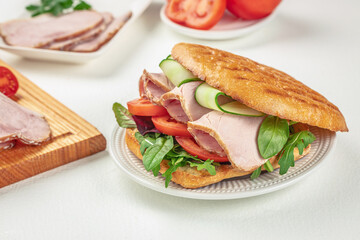 sandwich with pork ham, cheese and salad on a light background, top view. copy space