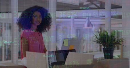 Image of stock market data processing over african american woman using computer at office - Powered by Adobe