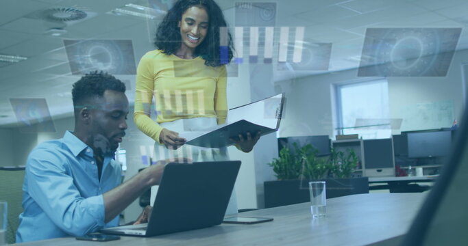Image of data processing over diverse man and woman discussing over laptop at office - Powered by Adobe