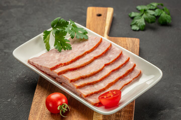 slices of square sandwich ham on plate on a dark background. top view. copy space for text