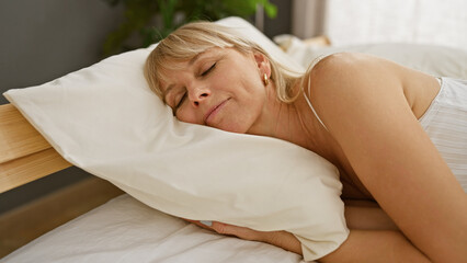 A serene caucasian woman napping peacefully on a pillow in a cozy bedroom setting.