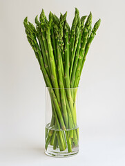 Bunch of fresh asparagus in glass vase on a table