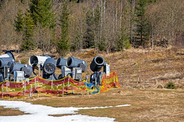 non-working snow generator on a slope without snow gear at a resort on a sunny day. Active...