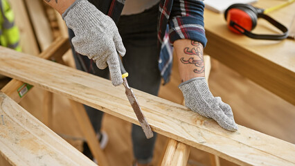 Middle age, grey-haired woman carpenter passionately sanding wood plank in her professional...