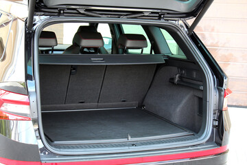 Car trunk. Clean trunk SUV car. Open back door modern SUV. The car is ready to load luggage. Modern black SUV open trunk. Car boot is open. Left view.