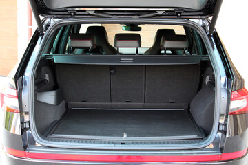 Car trunk. Clean trunk SUV car. Open back door modern SUV. The car is ready to load luggage. Modern black SUV open trunk. Car boot is open. Front view.