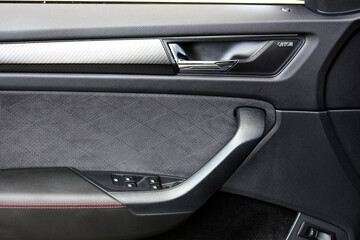 Car door control panel. Window lifters control. Car inside door handle. Armrest with setting adjustment button and blocking the opening and closing of doors. Door trim.