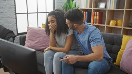 A concerned man comforting a woman on a sofa in a cozy living room while holding a remote. - obrazy, fototapety, plakaty