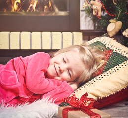 Little cute girl sleeping under the Christmas Tree waiting for Santa