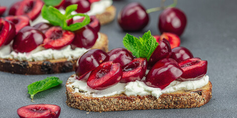 Fresh bread sandwiches with sweet cherry, cream cheese and mint leaves. Morning breakfast concept