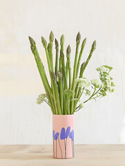 Bunch of fresh asparagus in vase on a table creative poster