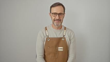 A mature man with glasses and a beard, wearing a brown apron, poses against a white background.