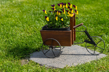 a tricycle decoration as a flower pot in a garden