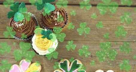 Image of st patrick's day shamrock and cupcakes on wooden background