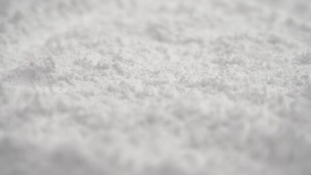 Nutrient potassium oxide powder falling in slow motion. Medical electrolyte mineral supplement. Rotation