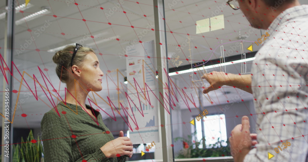 Poster image of multiple graphs with changing numbers over diverse coworkers reports on glass wall