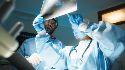 Doctors examine x-ray in surgery room