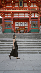 Beautiful hispanic woman in glasses, strolling by the fushimi inari taisha shrine, kyoto, adorning...