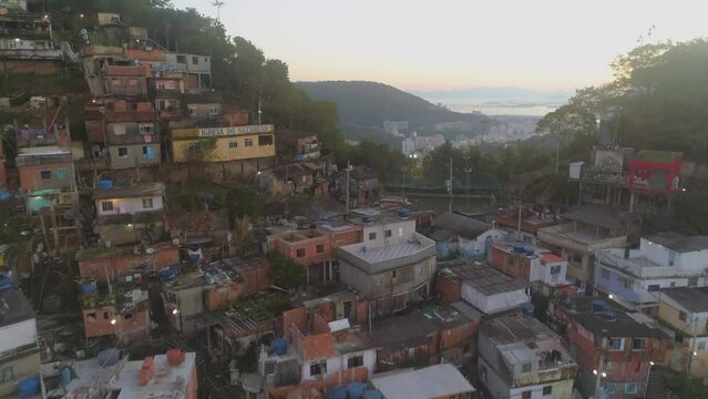 Rising up past hilltop favela houses to reveal Rio de Janeiro city and Guanabara Bay in the distance