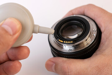 The photo lens is blown away from the dust by a pear. Care of photo optics.