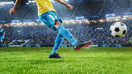 Obraz premium Aesthetic Shot Of Athletic Hispanic Footballer Shooting A Penalty Kick On Stadium With Crowd Cheering. Player Scoring a Goal At an International Soccer Championship Final Match With Fans On Tribune