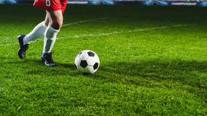 Obraz na płótnie Canvas Close-Up On Legs Of Professional Football Player Dribbling With A Ball During International Soccer Championship On National Arena. Athlete Running To Score A Winning Goal In Final Match On Stadium.