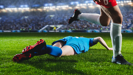 Aesthetic Shot of Blue Team Soccer Football Player Sliding on The Grass, Successfully Tackling the Opponent on Stadium With Croud Cheering. Dangerous Sports Moment During Intense Championship Final.