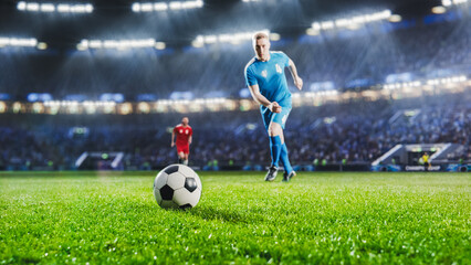 Football World Championship: Soccer Player Runs to Kick the Ball. Ball on the Grass Field of Arena, Full Stadium Crowd Cheers. International Tournament. Cinematic Shot Captures Victory.
