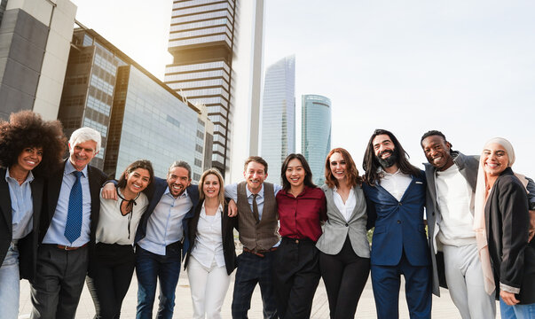 Group of multiethnic business people celebrating outdside of the office with financial  city in background - Corporate colleague and finance concept -  Main focus on center etrepreneurs faces