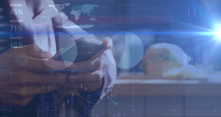 Image of graphs over hands of caucasian man using smartphone